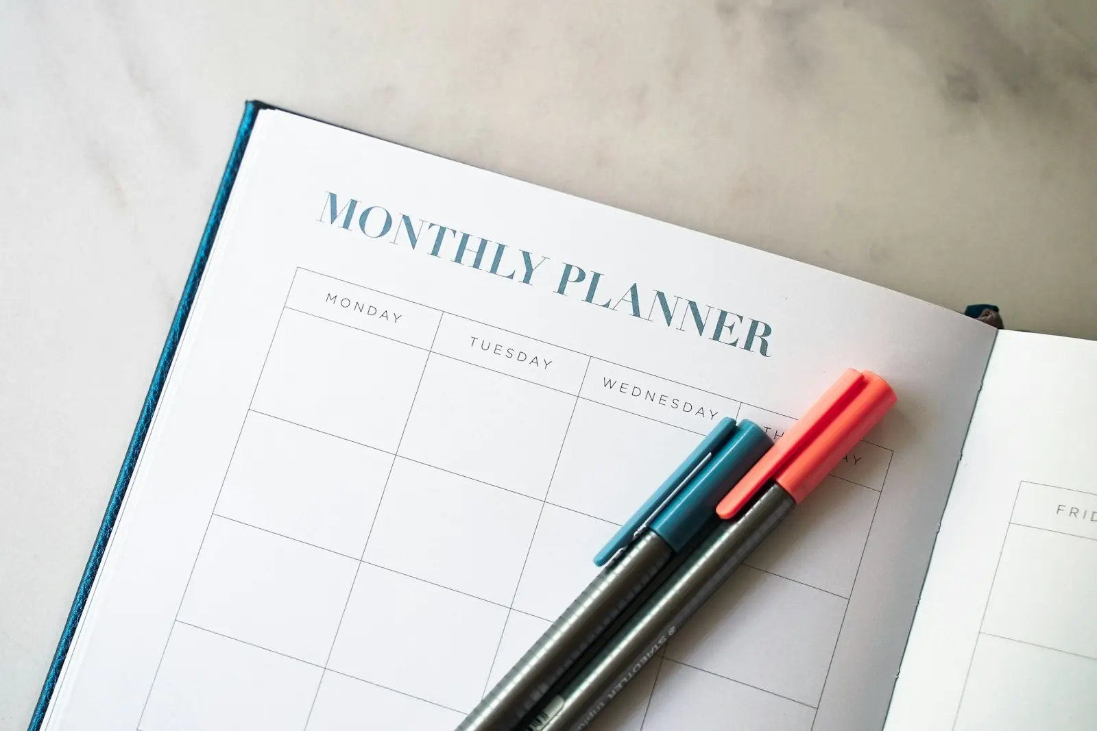 A monthly planner with two pens